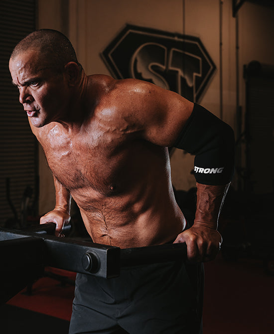 Male wearing elbow sleeves during dips