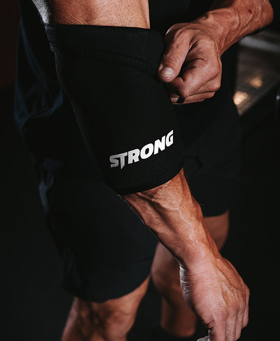 Male putting on elbow sleeves