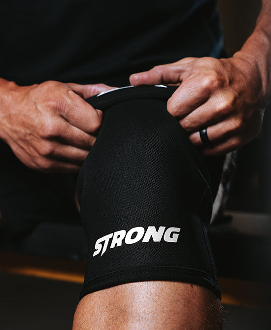 Male putting on knee sleeves