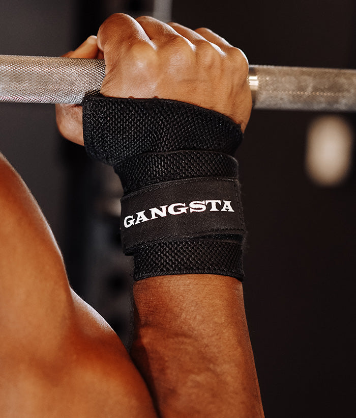 male wearing black gangsta wrist wraps holding a barbell