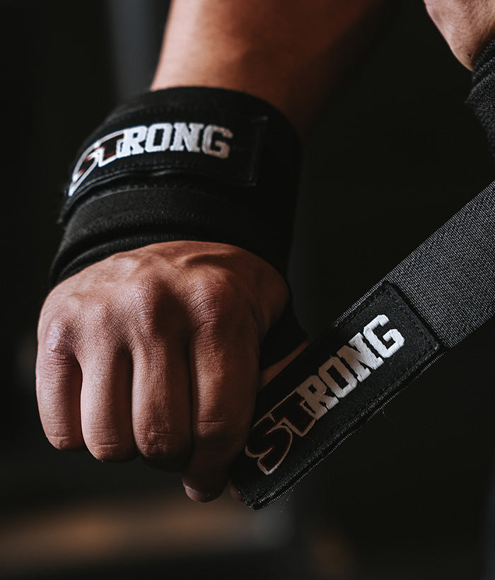 male putting on black wrist wraps