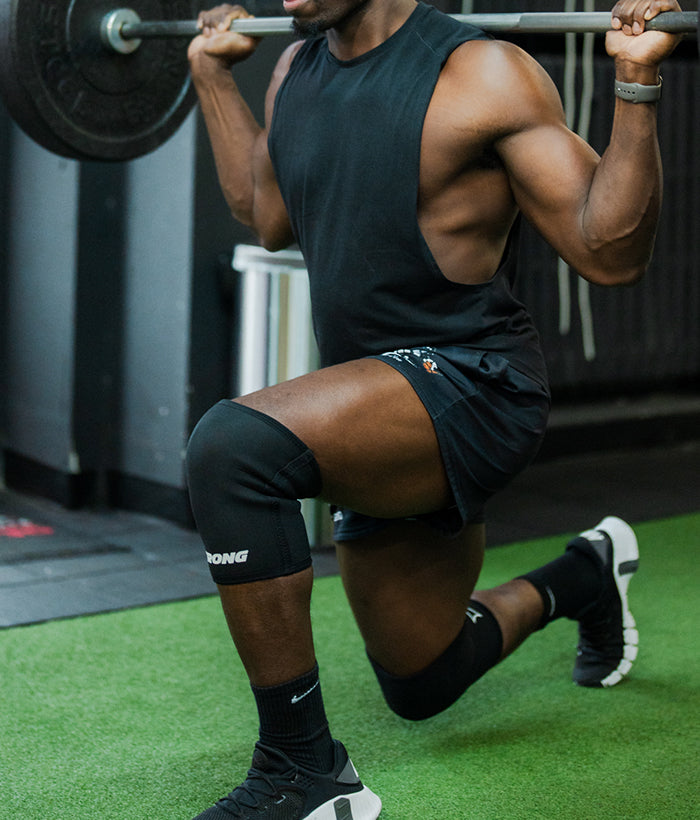 male doing lunges wearing all black knee sleeves